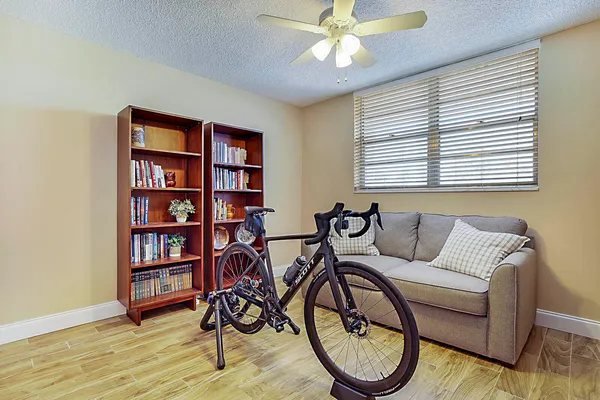 a living room with furniture a bookshelf and a window