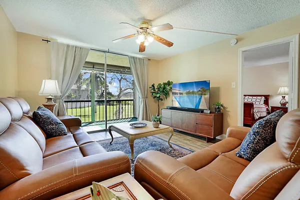 a living room with furniture a chandelier and a flat screen tv