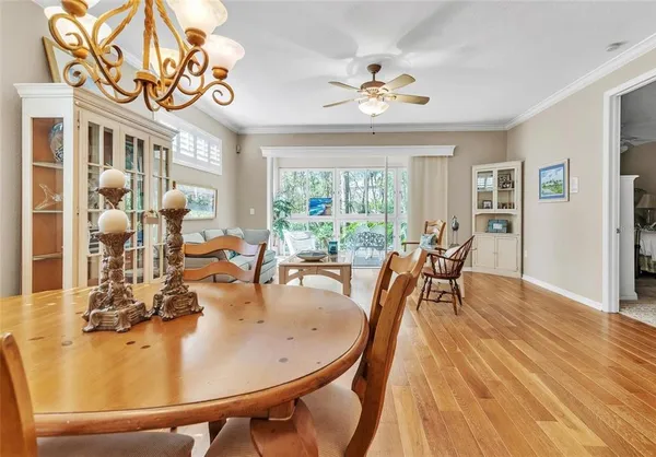 a dining room with furniture a chandelier and wooden floor