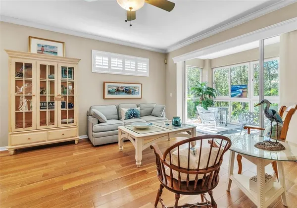 a living room with furniture two window and a flat screen tv
