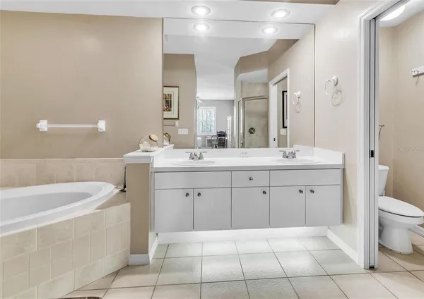 a spacious bathroom with a double vanity sink a mirror and a bathtub