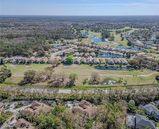 an aerial view of residential houses with outdoor space and lake view