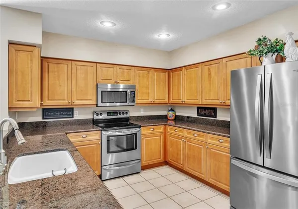 a kitchen with granite countertop a sink stainless steel appliances and cabinets