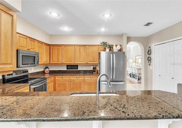 a kitchen with stainless steel appliances granite countertop a refrigerator stove microwave and sink