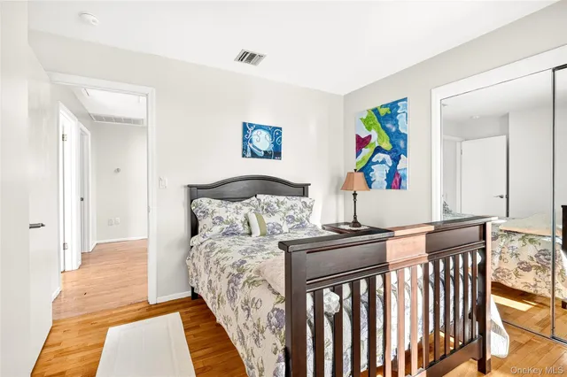 a bedroom with a bed and painting on the wall