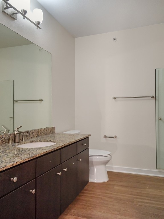 1900 Barton Springs Road, Unit 4013A Austin, TX 78704 - Photo 27 of 31 a bathroom with a granite countertop sink a toilet and a mirror