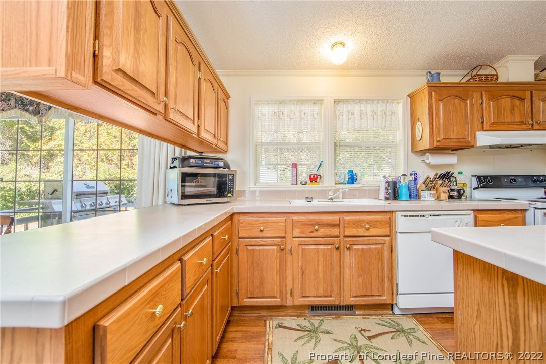 5384 Wade-Stedman Road Wade, NC 28395 - Photo 5 of 18 a kitchen with stainless steel appliances granite countertop a sink and cabinets