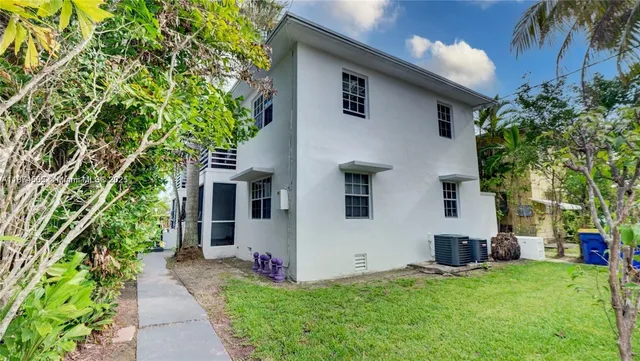 a house that has a tree in front of the house
