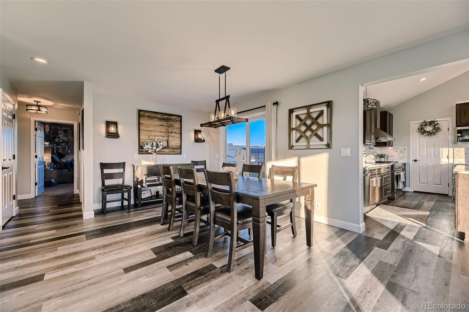 28242 Stone Horse Ranch Road Elbert, CO 80106 - Photo 7 of 39 a view of a dining room and livingroom with furniture wooden floor a rug a painting and a chandelier
