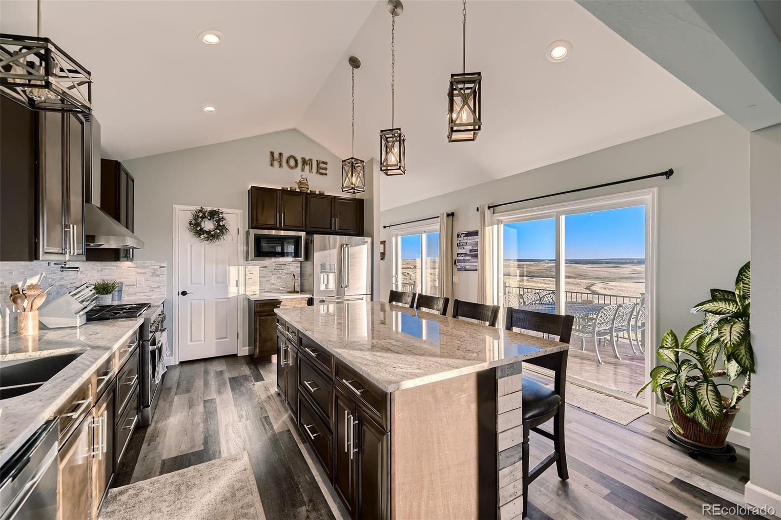28242 Stone Horse Ranch Road Elbert, CO 80106 - Photo 9 of 39 a kitchen with stainless steel appliances granite countertop a stove oven a sink a stove and a refrigerator