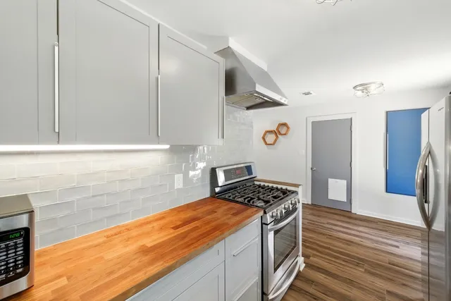 a kitchen with stainless steel appliances granite countertop a refrigerator and a stove