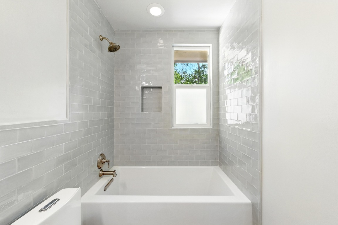 6209 Peggy Street Austin, TX 78723 - Photo 19 of 26 a white bath tub sitting in a bathroom next to a window