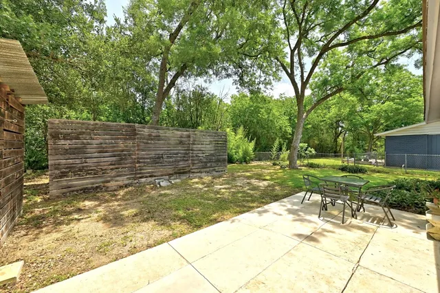 a view of backyard with wooden fence