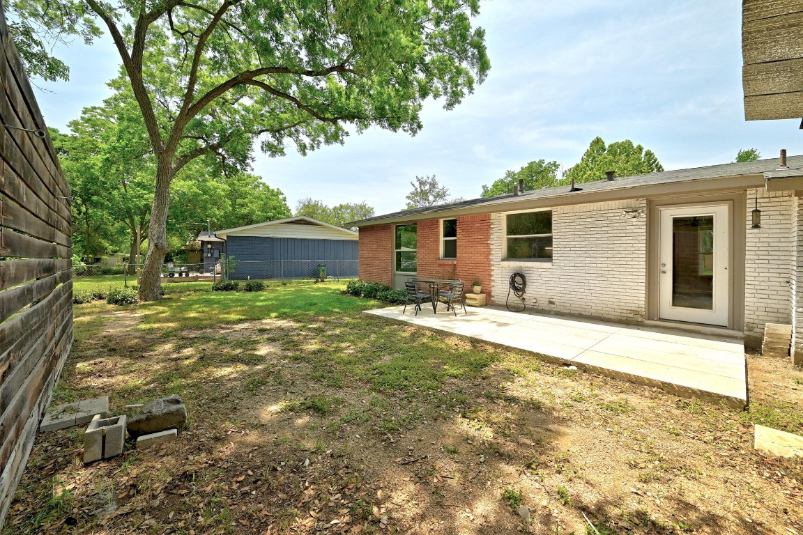 6209 Peggy Street Austin, TX 78723 - Photo 21 of 26 a backyard of a house with table and chairs under an umbrella