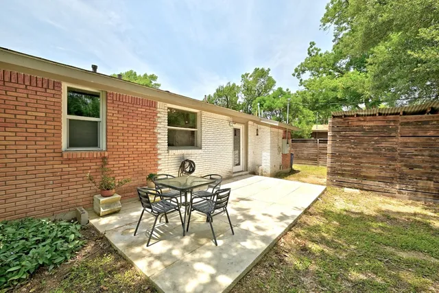 a backyard of a house with table and chairs