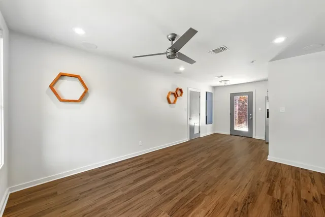 an empty room with wooden floor and windows