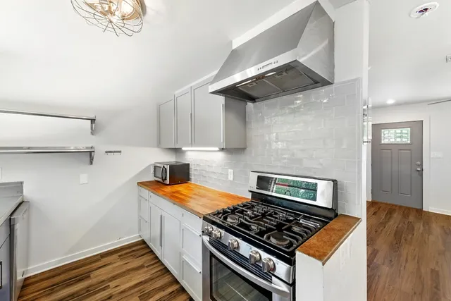 a kitchen with granite countertop a stove and a wooden floor