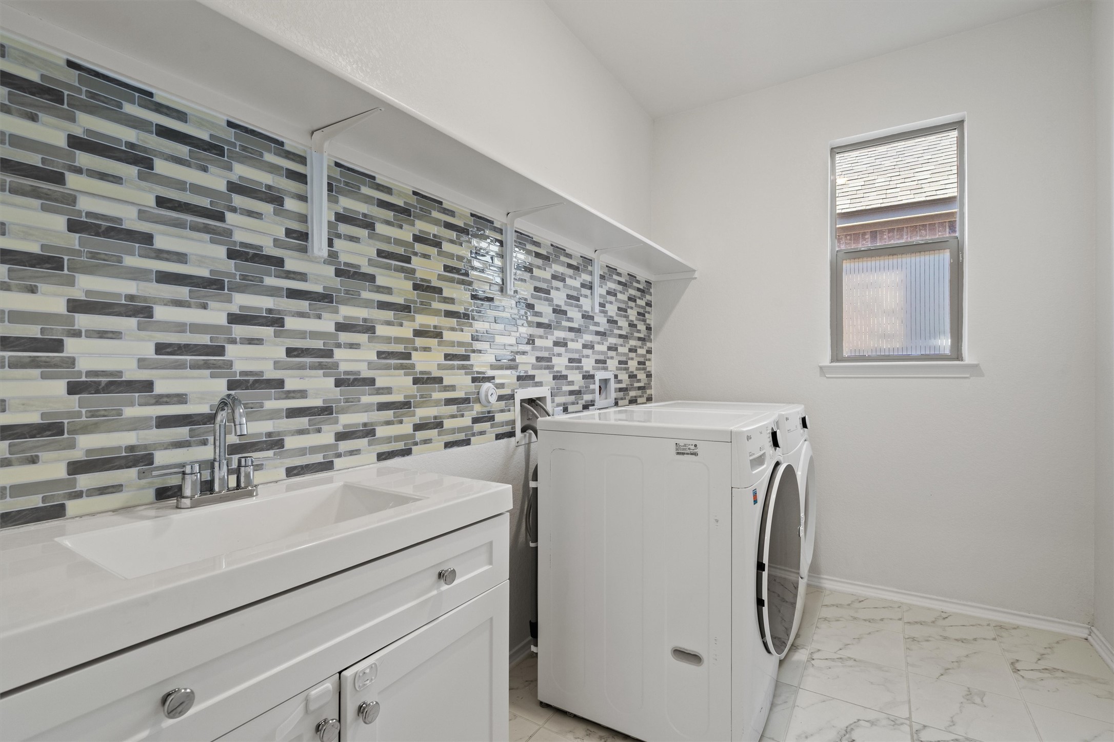 1901 Bogata Lane Leander, TX 78641 - Photo 19 of 40 Laundry room with separate washer and dryer and light marble finish flooring