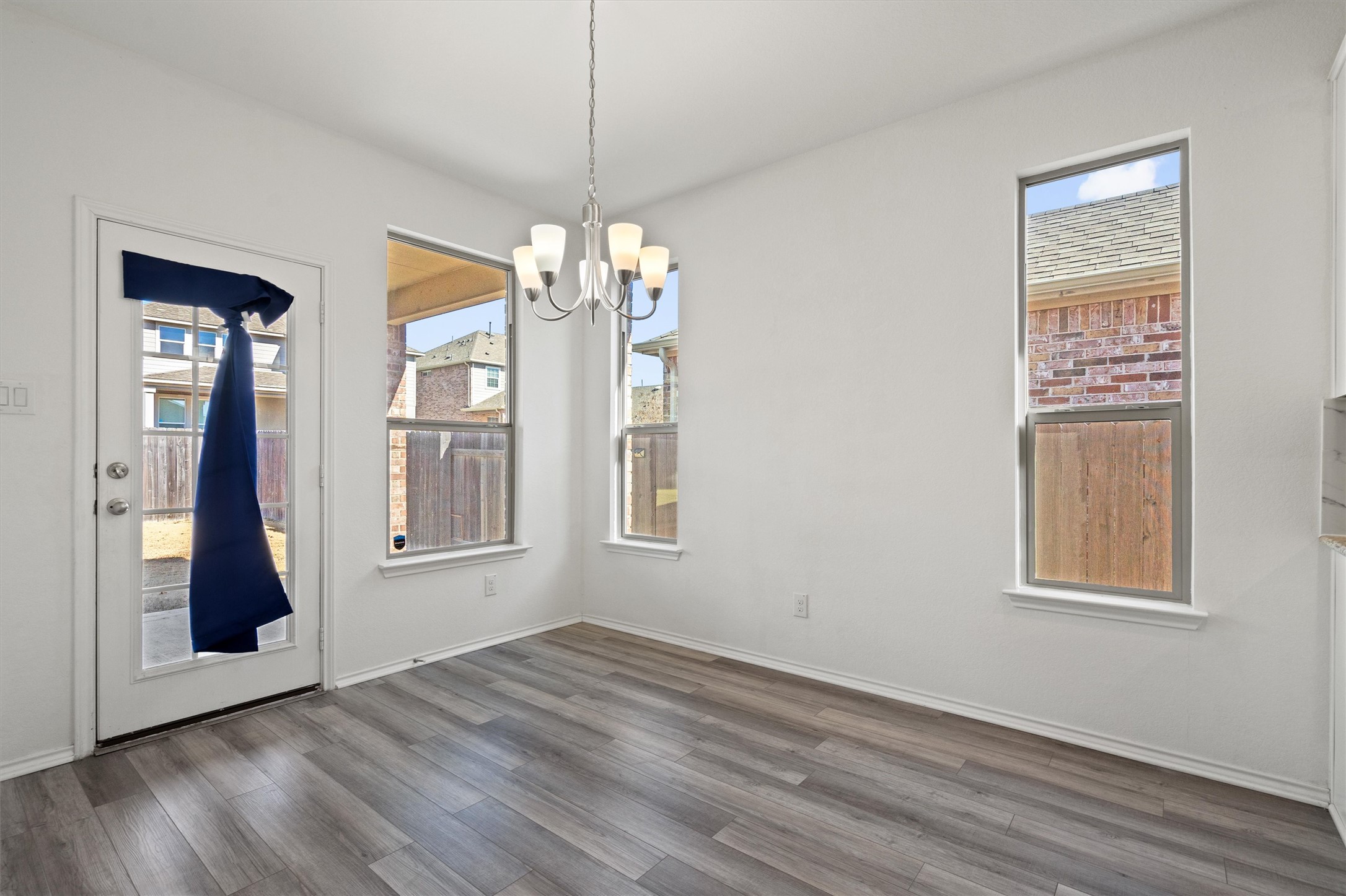1901 Bogata Lane Leander, TX 78641 - Photo 8 of 40 Unfurnished dining area with hanging lights and dark wood-style flooring