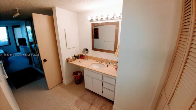 a bathroom with a sink and mirror with toilet