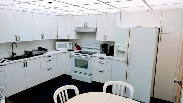 a kitchen with stainless steel appliances granite countertop a sink a stove a refrigerator and cabinets