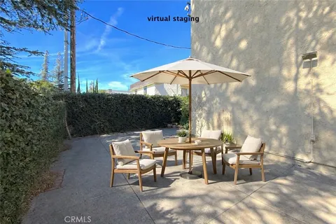a patio with a table and chairs under an umbrella