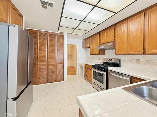 a kitchen with stainless steel appliances granite countertop a stove a sink and a refrigerator