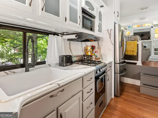 a kitchen with stainless steel appliances a stove a sink and a refrigerator