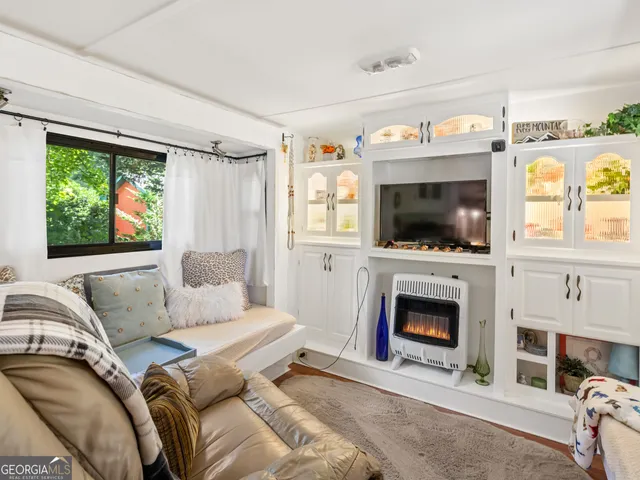 a living room with furniture a flat screen tv and a fireplace