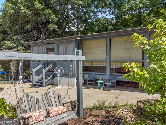 a view of a patio with table and chairs potted plants and large tree