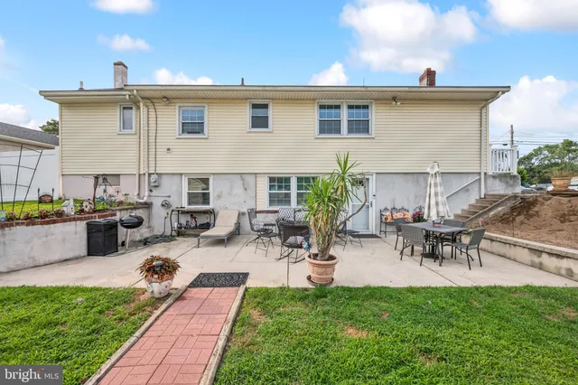 a view of a patio with table and chairs potted plants and a large tree
