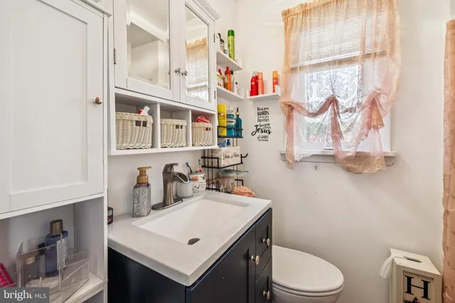 a bathroom with a sink a toilet and a shower curtain