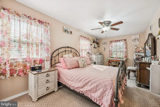 a bedroom with a bed a large window and flat screen tv