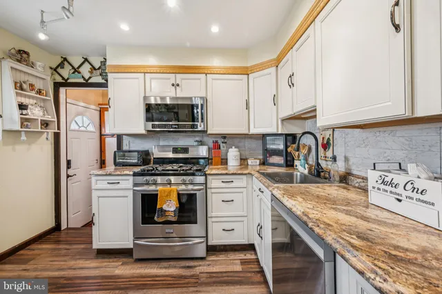a kitchen with stainless steel appliances granite countertop a stove and a sink