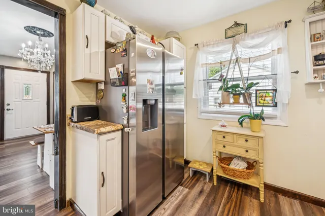 a kitchen with a refrigerator and wooden floor