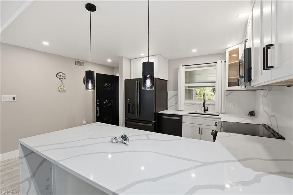 1320 Blue Point Avenue, Unit 2 Naples, FL 34102 - Photo 3 of 35 a large white kitchen with a sink a refrigerator and chairs
