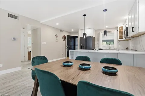 a kitchen with white cabinets and wooden floor