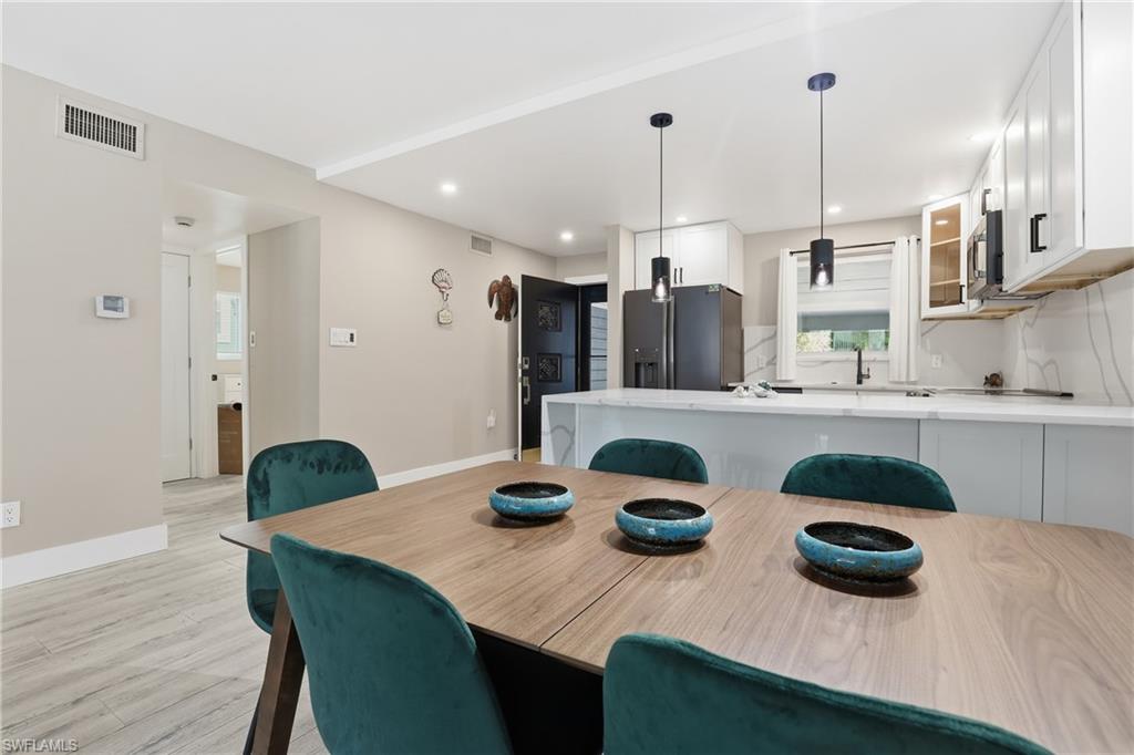 1320 Blue Point Avenue, Unit 2 Naples, FL 34102 - Photo 4 of 35 a kitchen with white cabinets and wooden floor