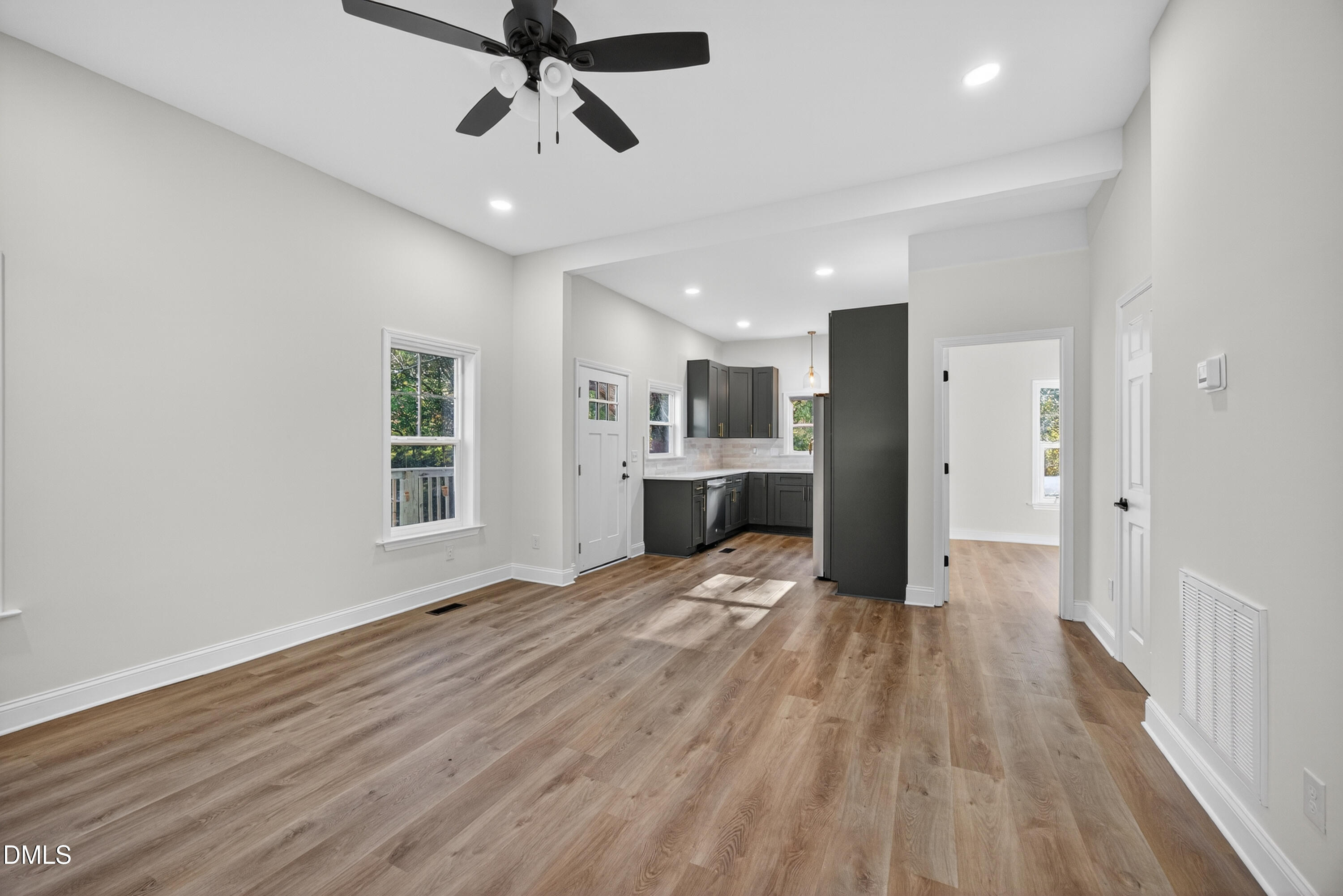 1043 George Bason Road Graham, NC 27253 - Photo 10 of 30 a view of kitchen and empty room with wooden floor and windows