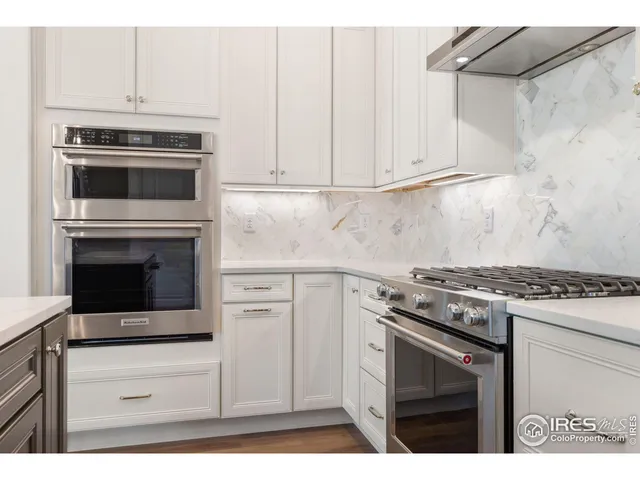 a kitchen with kitchen island granite countertop a stove a refrigerator and cabinets