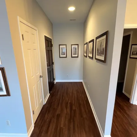 a view of a hallway with wooden floor and staircase