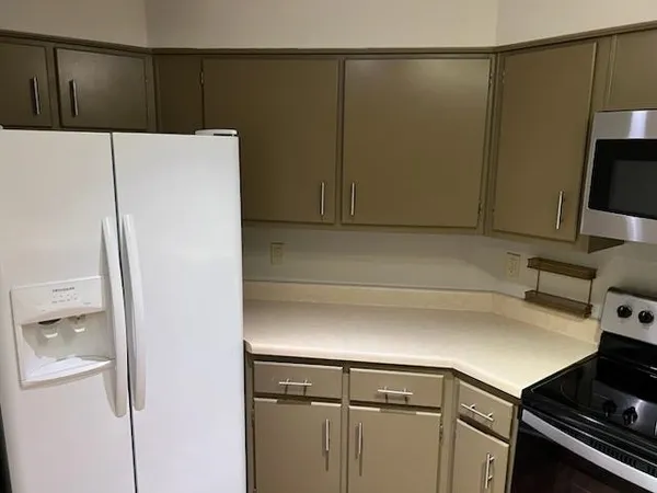 a kitchen with a refrigerator and a stove