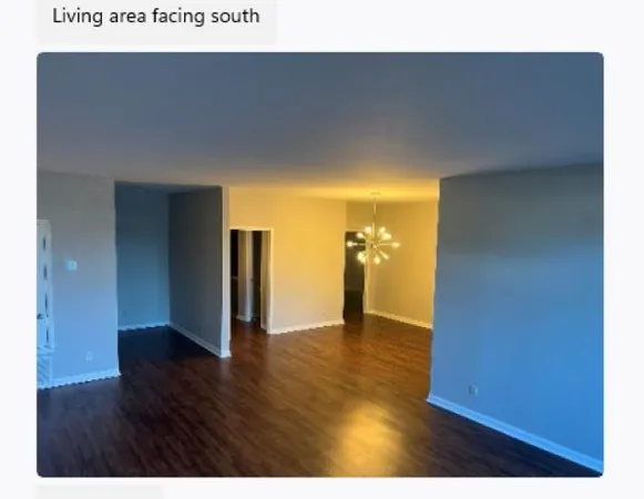a view of an empty room with wooden floor and closet