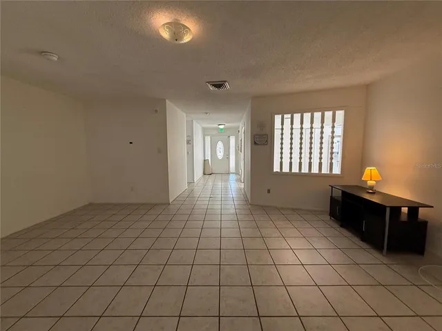 an empty room with white walls and windows