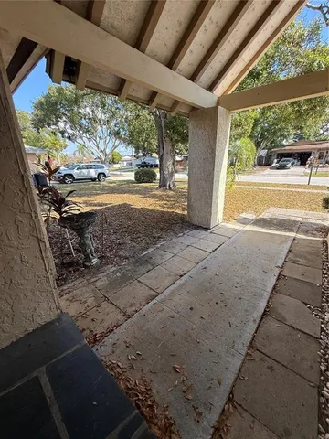a view of a porch with furniture and a yard