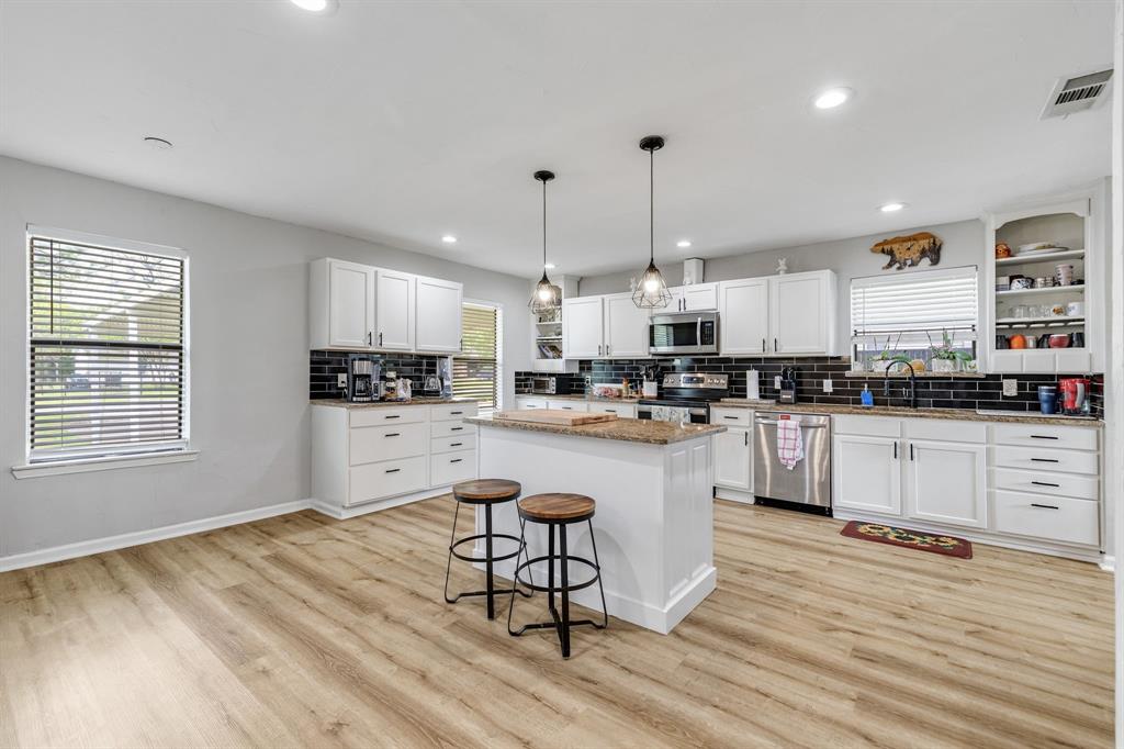 191 Klutts Road McLendon-Chisholm, TX 75032 - Photo 5 of 40 a kitchen with stainless steel appliances granite countertop wooden floors refrigerator and cabinets