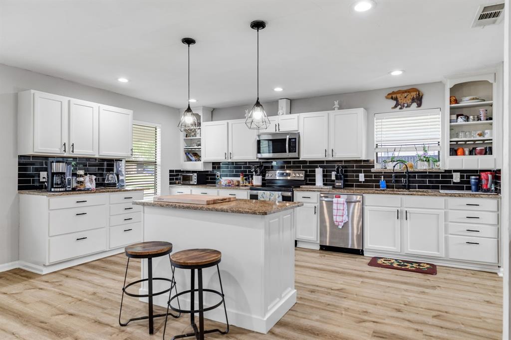 191 Klutts Road McLendon-Chisholm, TX 75032 - Photo 6 of 40 a kitchen with white cabinets stainless steel appliances and kitchen island