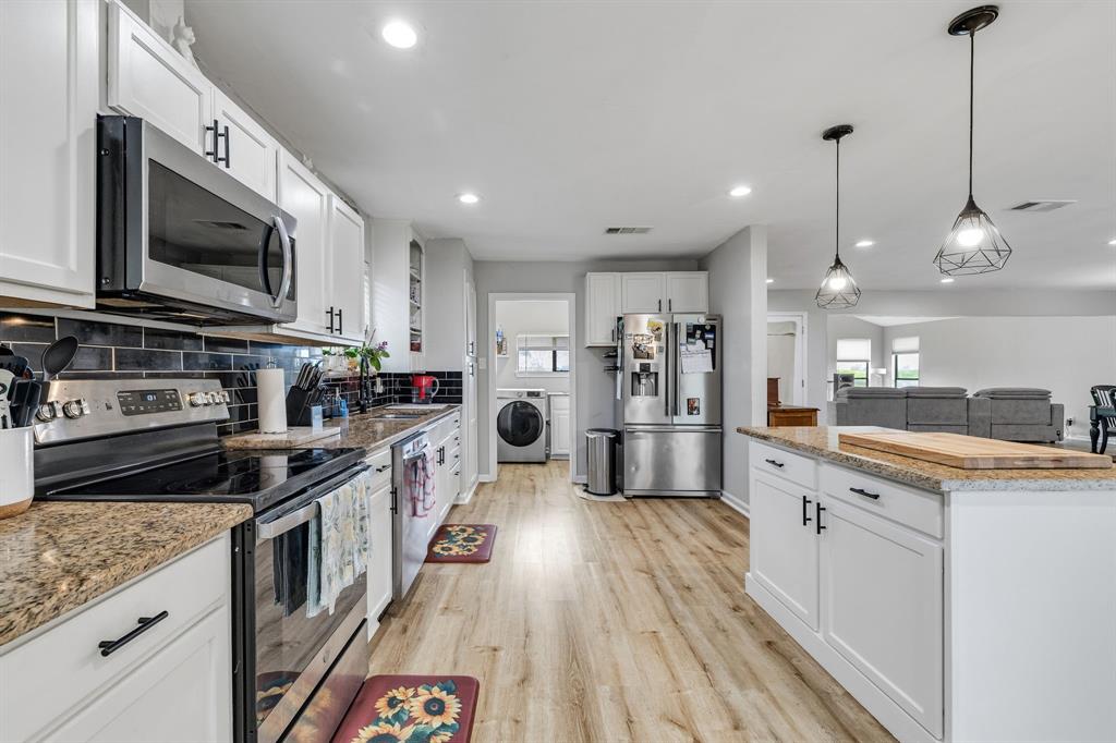 191 Klutts Road McLendon-Chisholm, TX 75032 - Photo 10 of 40 a kitchen with stainless steel appliances granite countertop a stove a sink and a microwave