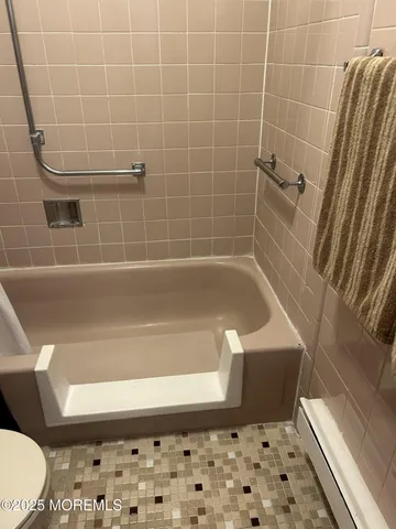 a bathroom with a bathtub and toilet