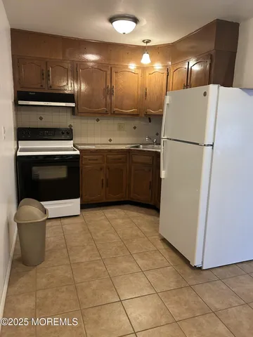 a kitchen with a refrigerator and a stove
